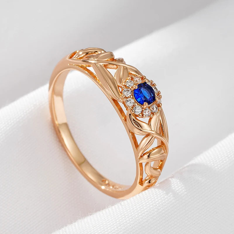 Anel Encantado com Design Vazado de Folhas e Zircônia Azul Central, Acabamento em Ouro Rosé 14K