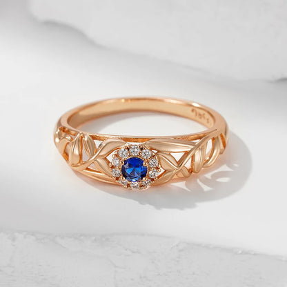 Anel Encantado com Design Vazado de Folhas e Zircônia Azul Central, Acabamento em Ouro Rosé 14K